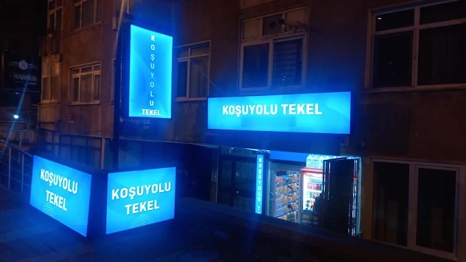 Koşuyolu Tekel'in gece ışıklı mavi tabelalı dükkan cephesi